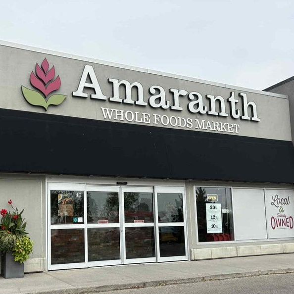 Amaranth Whole Foods Market storefront with a black awning and stone facade.